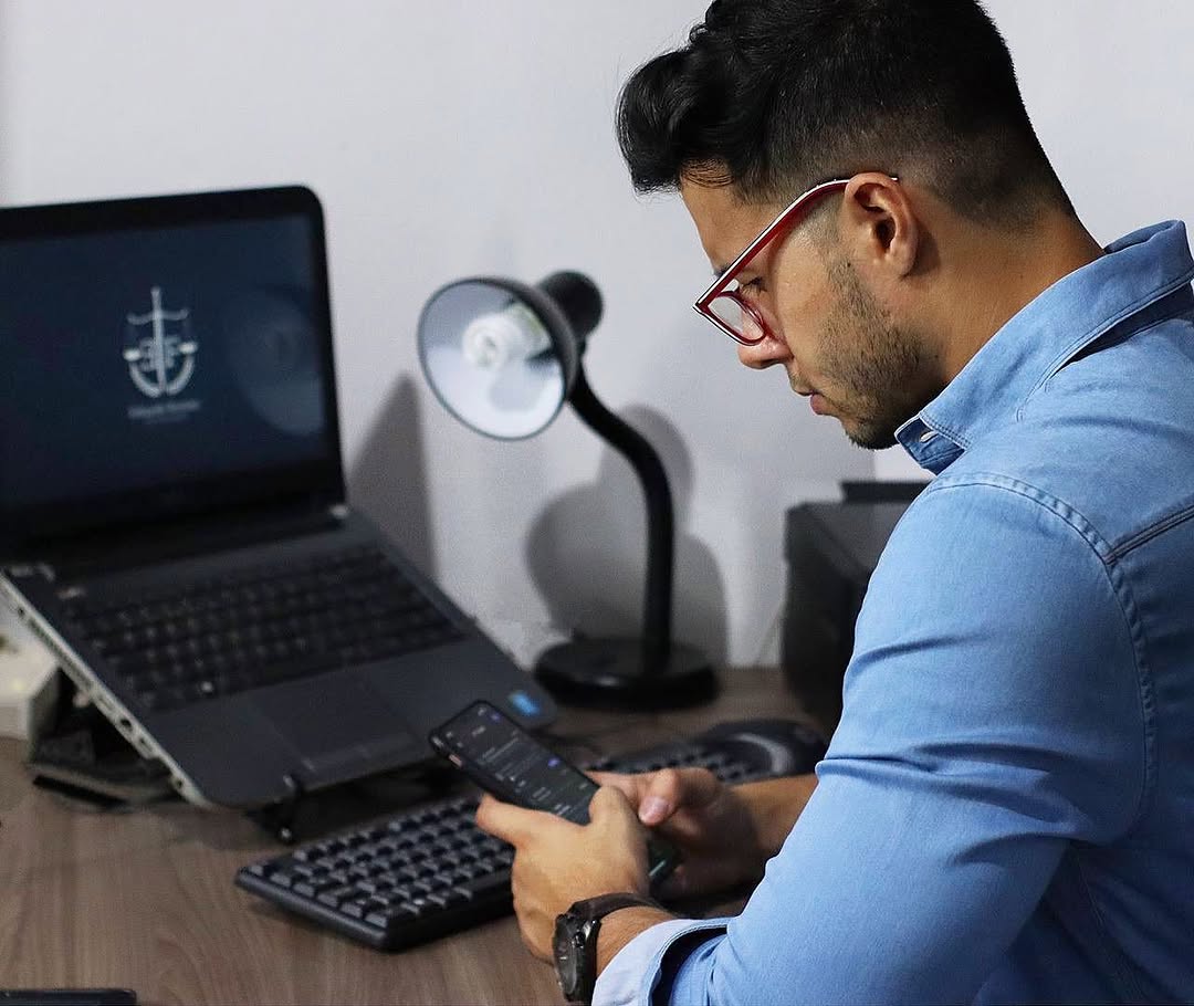 Eduardo Ferreira trabalhando em seu escritório, ao lado do notebook
